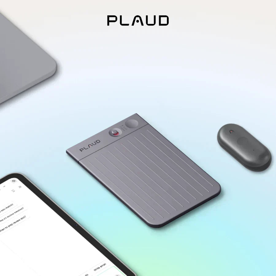 Un Plaud Note gris et un Plaud NotePin gris foncé posés près d'un ordinateur portable et d'une tablette sur un fond moderne.