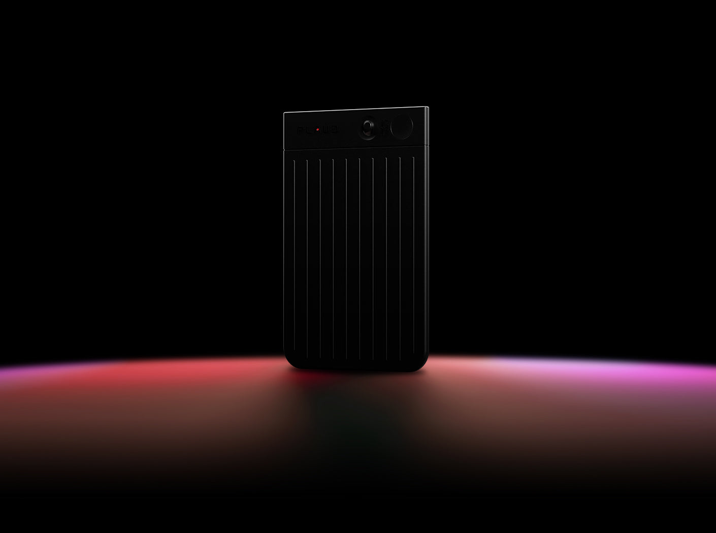 Un Plaud Note noir avec un voyant d'enregistrement rouge est posé sur une surface sombre