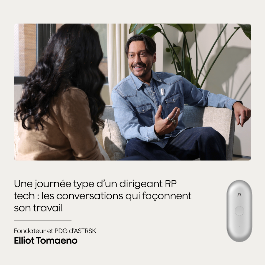Un homme souriant portant un Plaud NotePin S blanc sur sa chemise discute avec une femme dans un cadre professionnel.