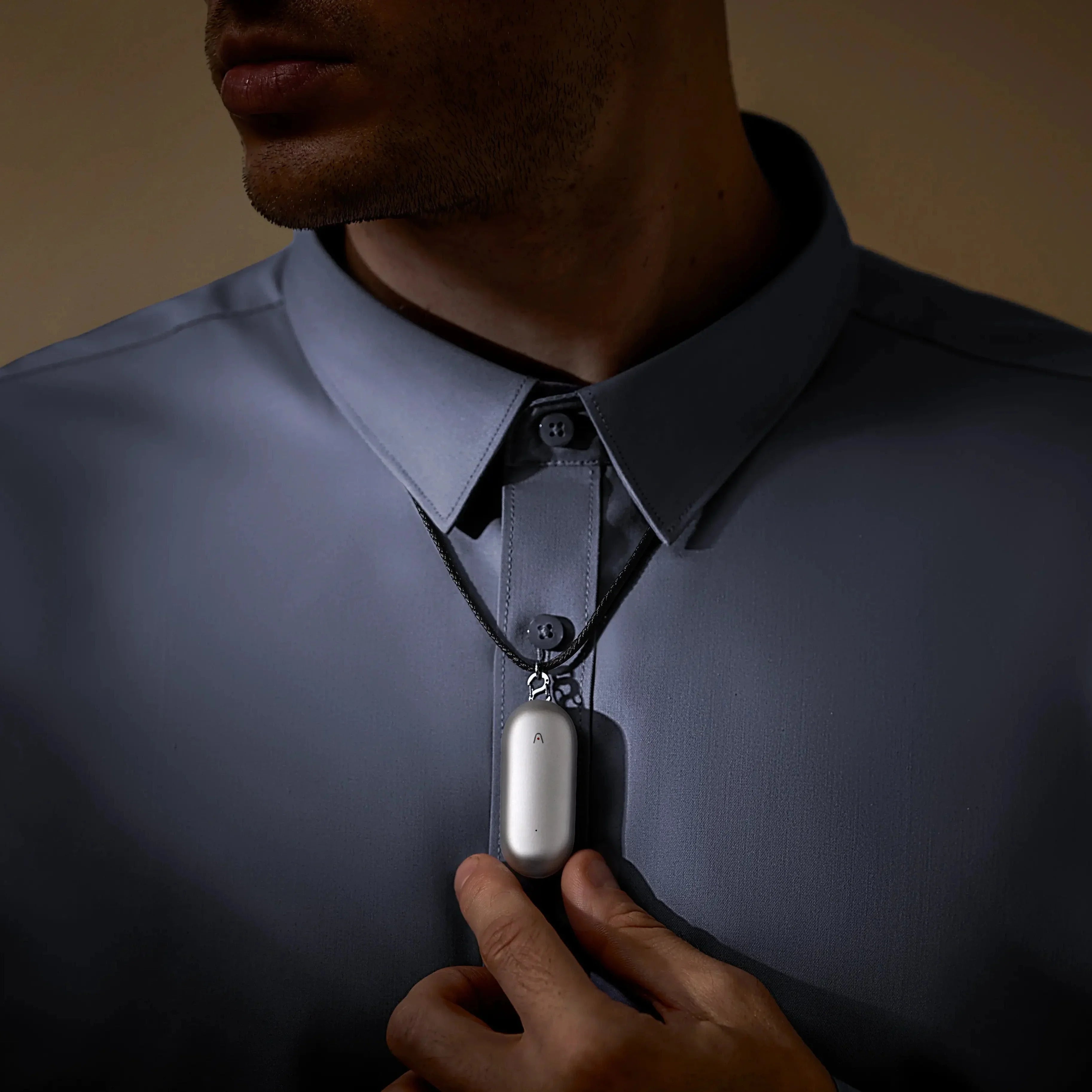 Homme portant un pendentif IA argenté autour du cou