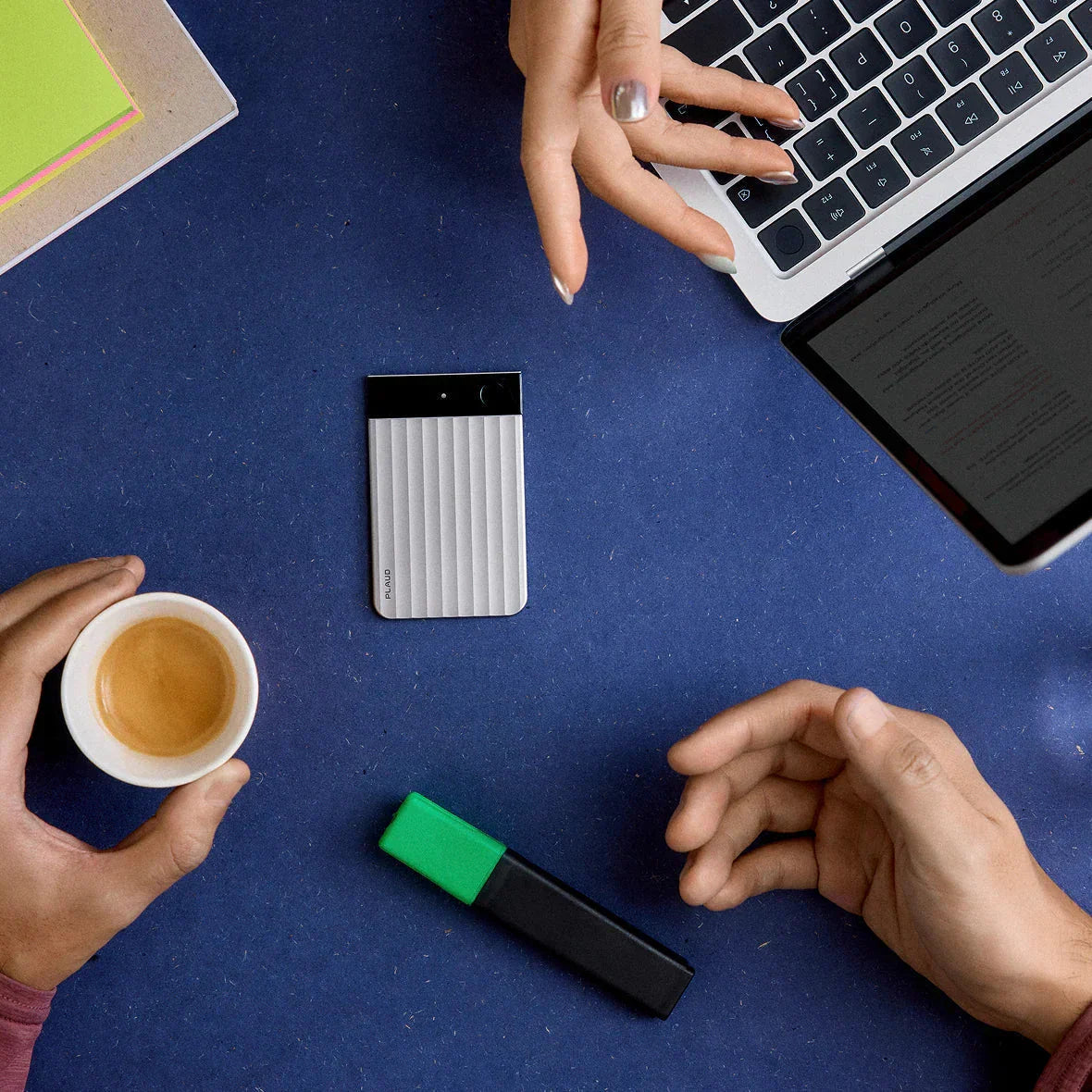 Espace de travail avec l'appareil Plaud, un café et un ordinateur portable