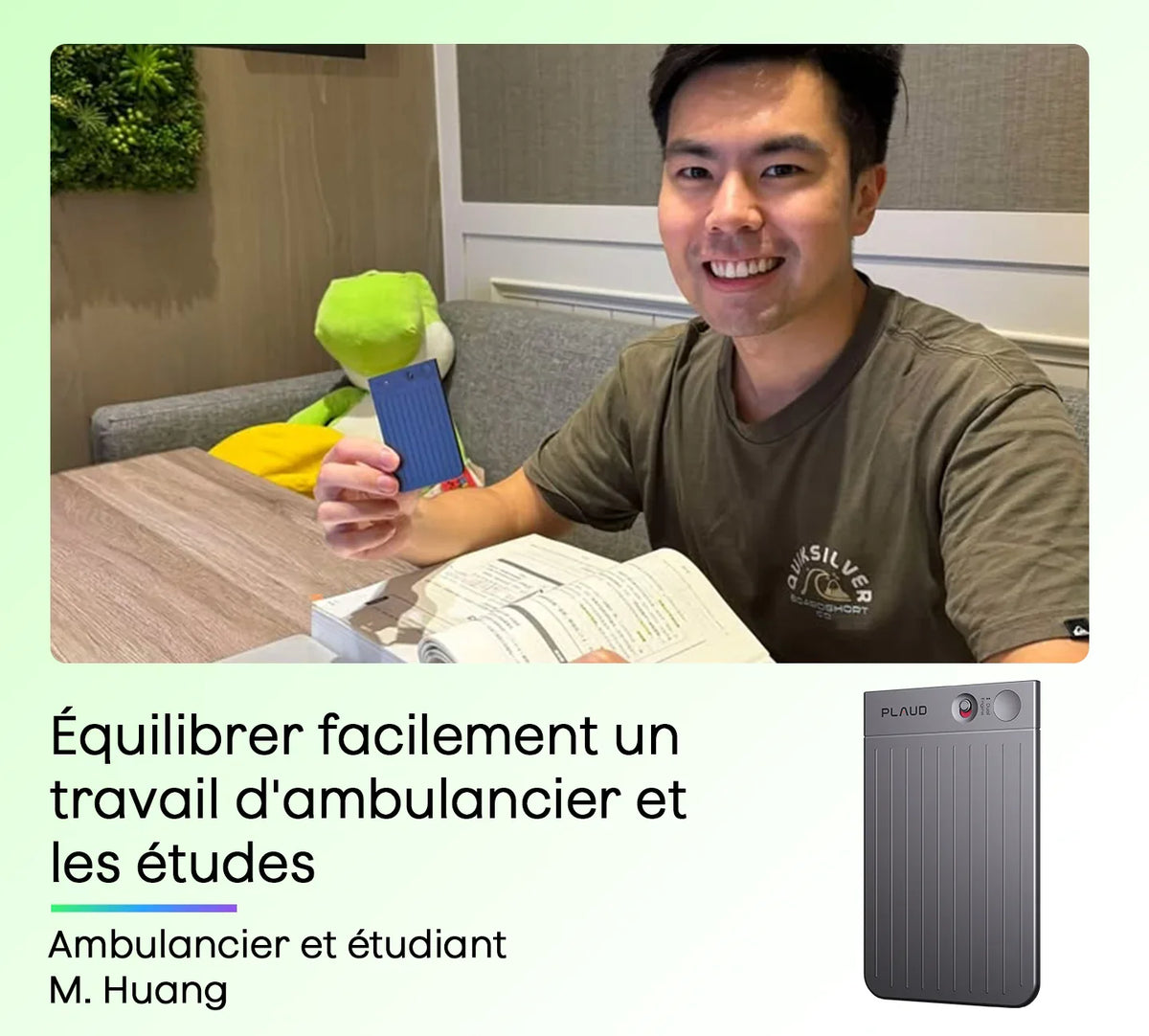 Un jeune homme souriant tient un Plaud Note bleu nervuré, étudiant à une table avec un livre ouvert.