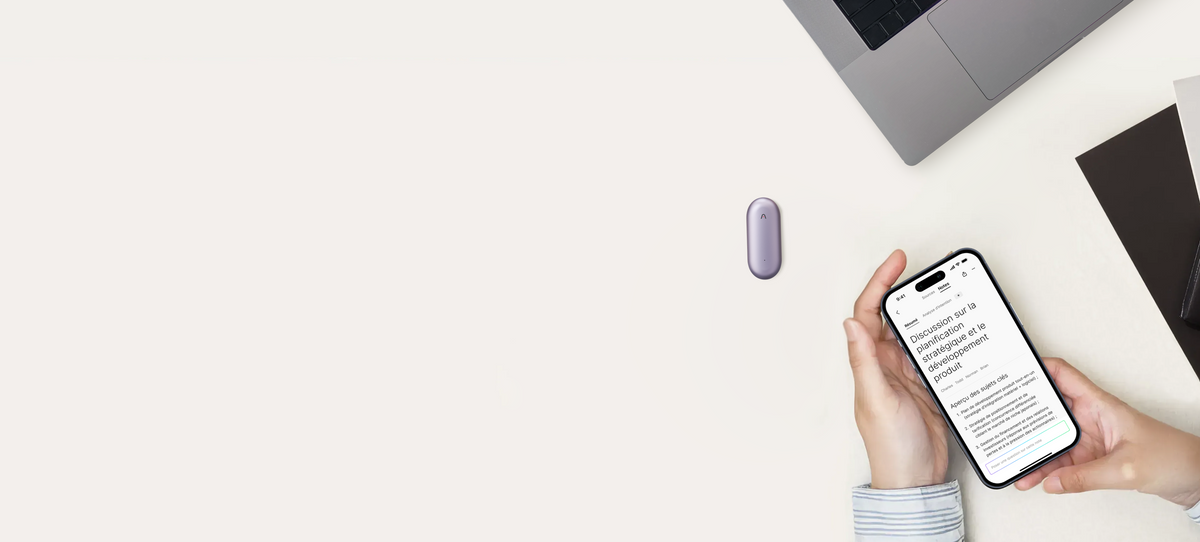 Un Plaud NotePin violet sur un bureau blanc, tandis qu'une personne consulte un résumé de réunion stratégique sur l'application Plaud via son smartphone.