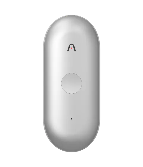 Un enregistreur Plaud NotePin S argenté en forme de capsule, doté d'un bouton central et d'un logo en arche avec un point rouge.